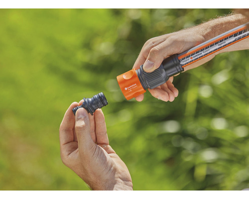 Osoba pripája kus záhradnej hadice k záhradnej hadici