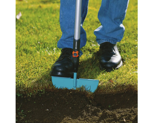 Osoba používa obrubník trávnika v záhrade.