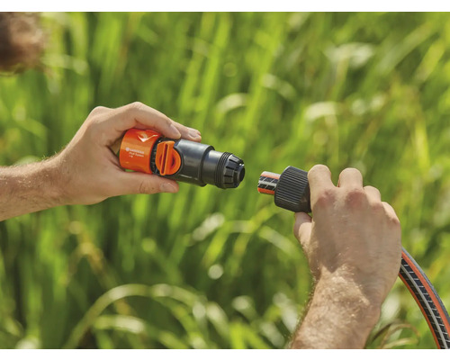 Osoba pripája hadicový konektor Gardena k vodovodnému kohútiku.