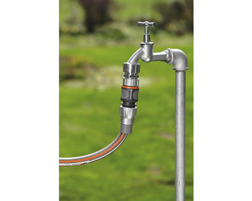 Záhradná hadica pripojená k vodovodnému kohútiku pomocou hadicovej spojky
