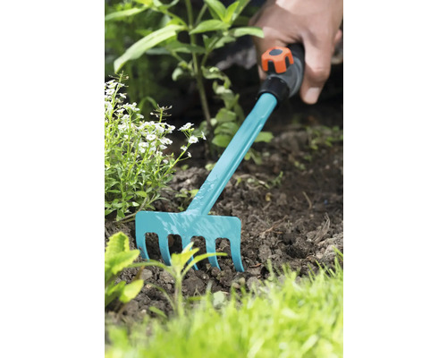 Záhradníctvo s malými hrabľami v záhone.