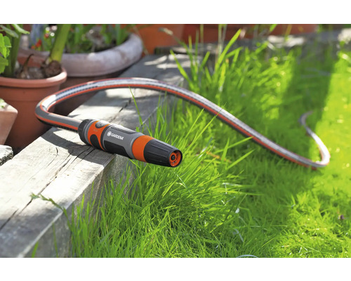 Záhradná hadica Gardena s tryskou na drevenom povrchu