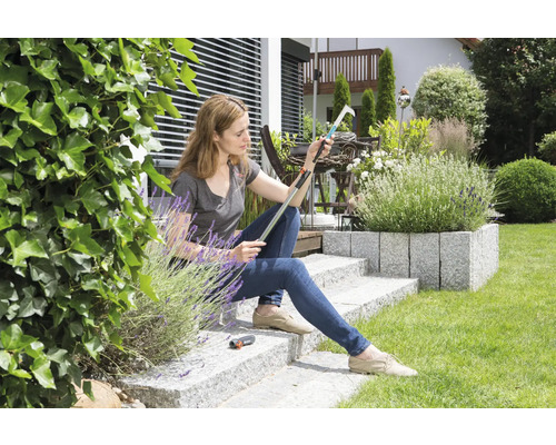 Žena sedí v záhrade a kontroluje zberač ovocia