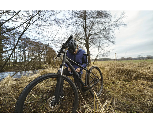 Muž opravuje svoj bicykel v prírode