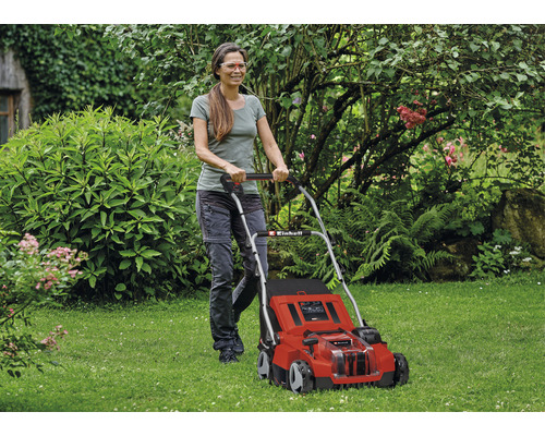 Žena obsluhuje červenú kosačku na trávu Einhell v záhrade.