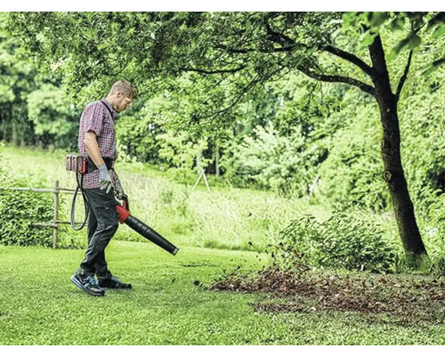 Osoba používa fúkač lístia na záhradnícke práce.