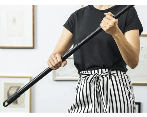 Osoba drží čiernu násadu na mop.