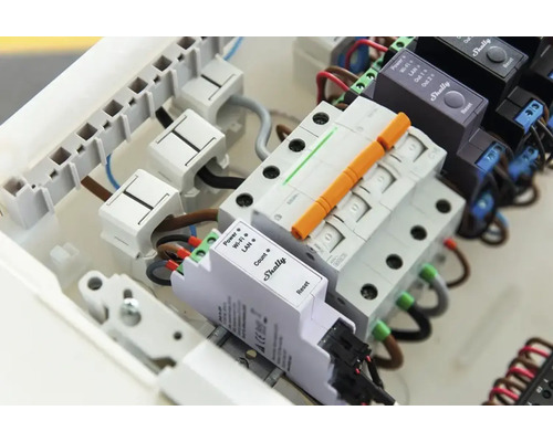 Zapojená rozvodná skriňa s komponentmi Shelly, vrátane napájacích káblov a poistiek.