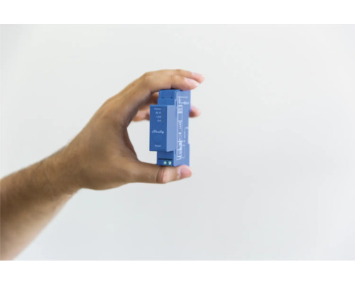 Ruka drží automatizačné zariadenie Shelly