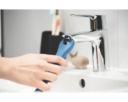 Osoba inštaluje vodovodný kohútik pomocou špeciálneho kľúča v kúpeľni