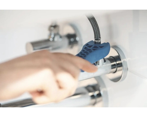 Osoba používa ventilový kľúč na rohový ventil