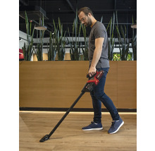 Muž vysáva podlahu akumulátorovým vysávačom.