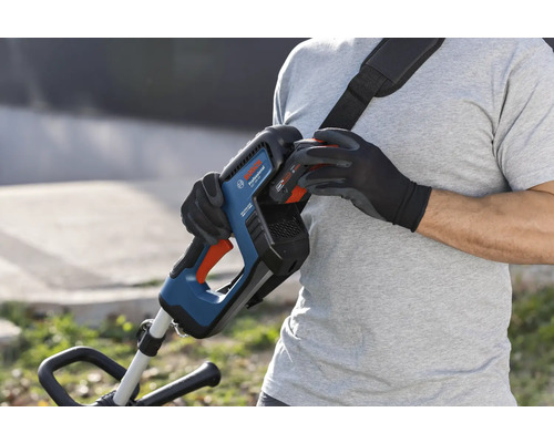 Osoba vymieňa batériu akumulátorového vyžínača Bosch s popruhom