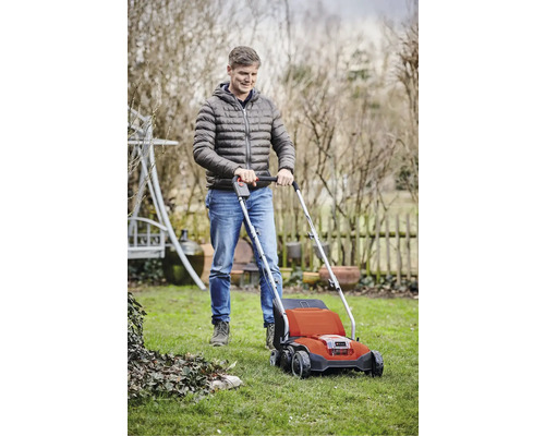 Muž používa prevzdušňovač trávnika v záhrade.