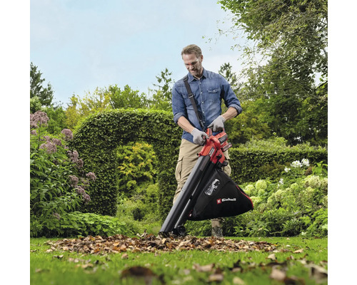 Muž používa na záhrade vysávač lístia na odstránenie lístia.