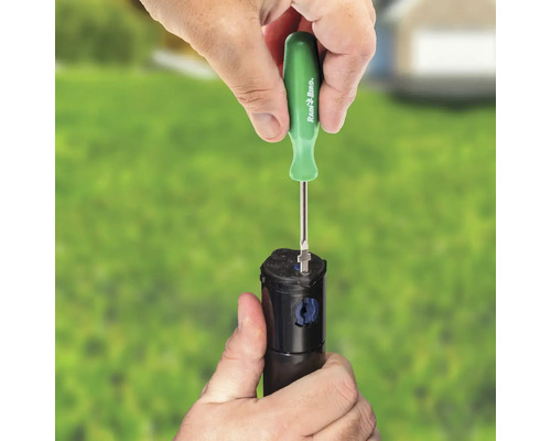Osoba nastavuje zavlažovač pomocou skrutkovača Rain Bird.