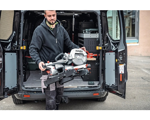 Muž ukladá pokosovú pílu Metabo do dodávky.