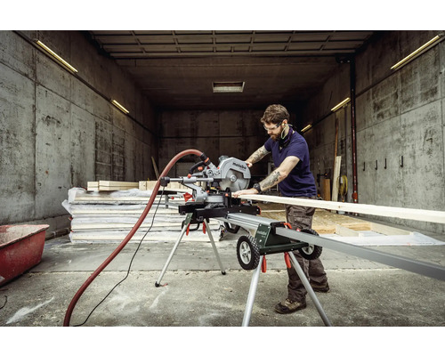 Muž pracuje s pokosovou pílou Metabo v dielni na rezanie dreva.