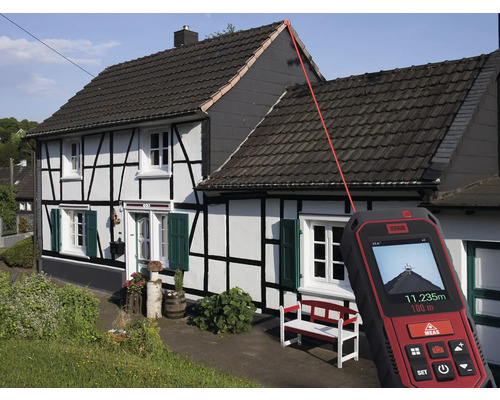 Laserový diaľkomer meria dĺžku strechy domu.