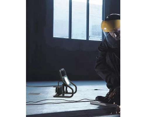 Pracovná lampa v prevádzke s osobou brúsiacou kov