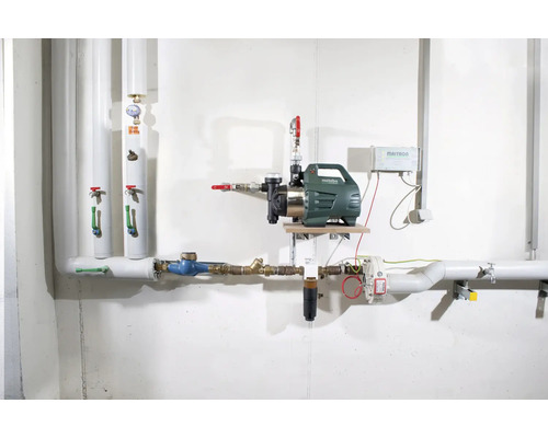 Inštalácia domácej vodárne s čerpadlom, potrubím a súvisiacou technológiou na stene