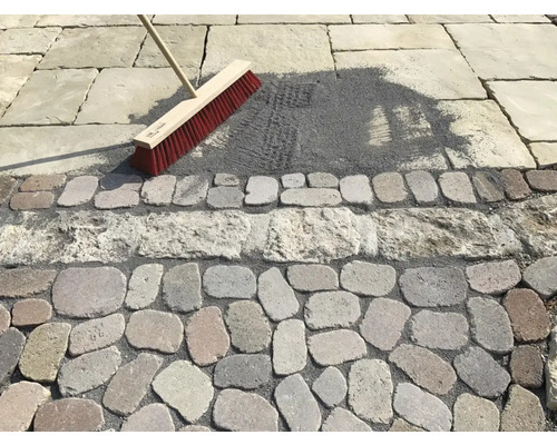 Scéna čistenia škár dlažby metlou