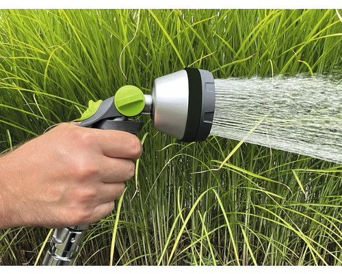 Záhradná hadica striekacia hlava v prevádzke pred zelenou trávou