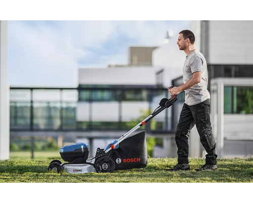 Muž obsluhuje akumulátorovú kosačku Bosch v záhrade.