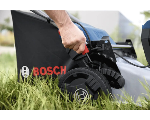 Detailný záber kosačky na trávu v prevádzke s košom a logom Bosch