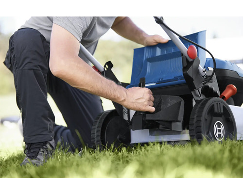 Osoba pripravuje kosačku na trávu na záhradníctvo