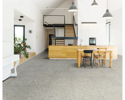 Svetlá obývacia izba so sivou dlažbou, kuchynským stolom a schodiskom