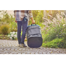 Osoba nesie záhradný vak Gardena v záhrade.