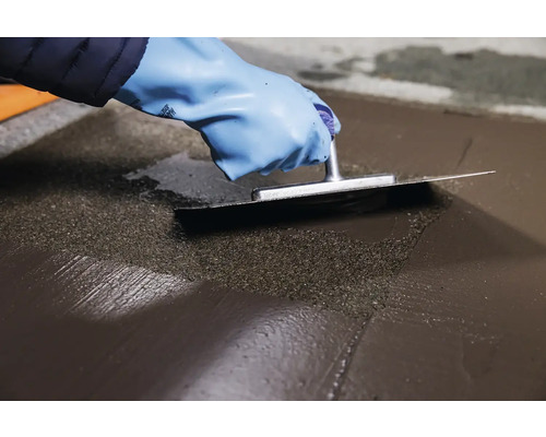 Remeselník hladí poter hladidlom