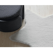 Koberec v tvare hviezdy vedľa kresla na drevenej podlahe