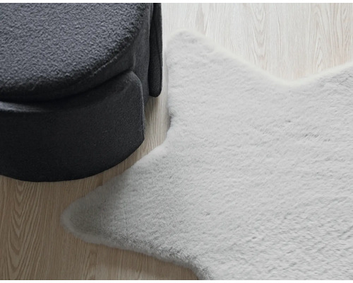 Koberec v tvare hviezdy vedľa kresla na drevenej podlahe