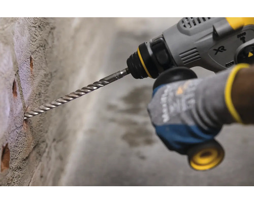 Vŕtačka vŕta diery do steny.