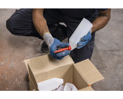 Osoba umiestňuje červený výtok na prázdnu plastovú fľašu nad kartónom s ďalšími fľašami.