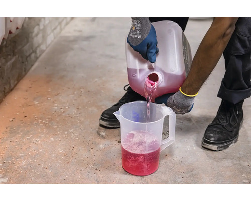 Osoba nalieva ružovú tekutinu z nádoby do odmerky.