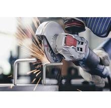 Osoba reže kovový kus uhlovou brúskou a iskry lietajú.