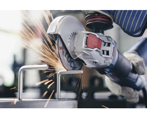 Osoba reže kovový kus uhlovou brúskou a iskry lietajú.