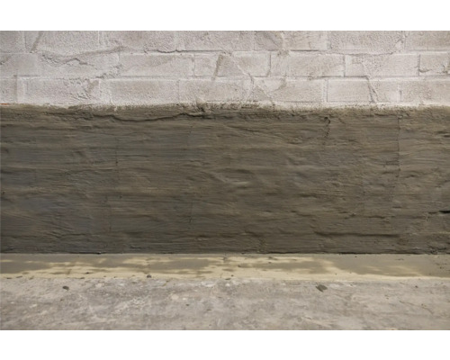 Tehlová stena, čiastočne potiahnutá bariérou proti vlhkosti