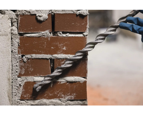 Špirála sa zavádza do tehlovej steny.