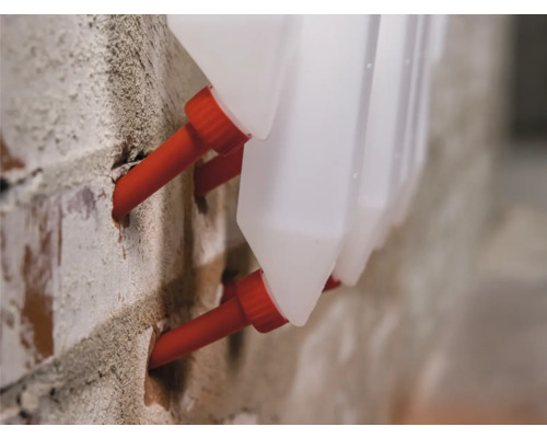 Vlhké steny s injektážnymi tryskami a zásobníkmi injektážnej látky na tehlovej stene.