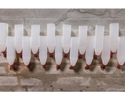 Rad bielych napájadiel pre zvieratá na betónovej stene