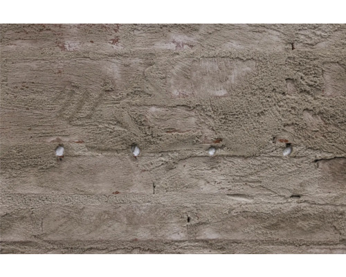 Detail omietnutej tehlovej steny s otvormi