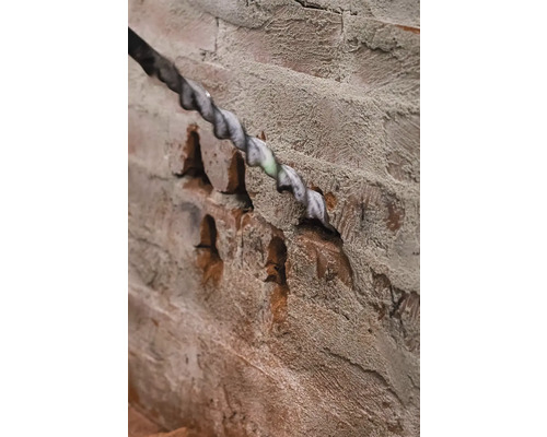 Vŕtačka vŕta otvor do tehlovej steny