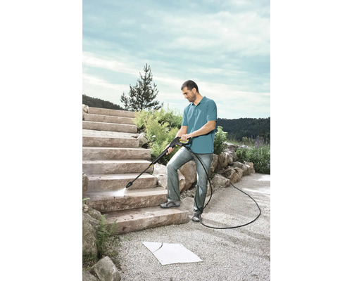 Muž čistí kamenné schody vysokotlakovým čističom