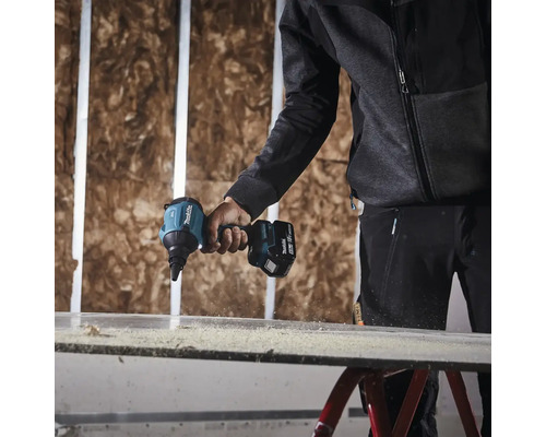 Osoba používa akumulátorový skrutkovač na sadrokartón značky Makita na skrutkovanie sadrokartónovej steny.