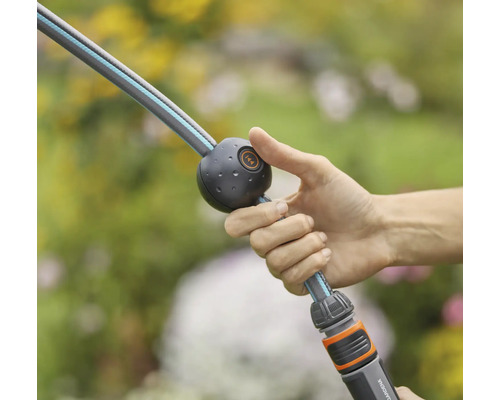 Osoba drží záhradnú hadicu s funkciou vodnej zarážky.