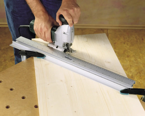 Remeselník používa priamočiaru pílu s vodiacou lištou na drevo